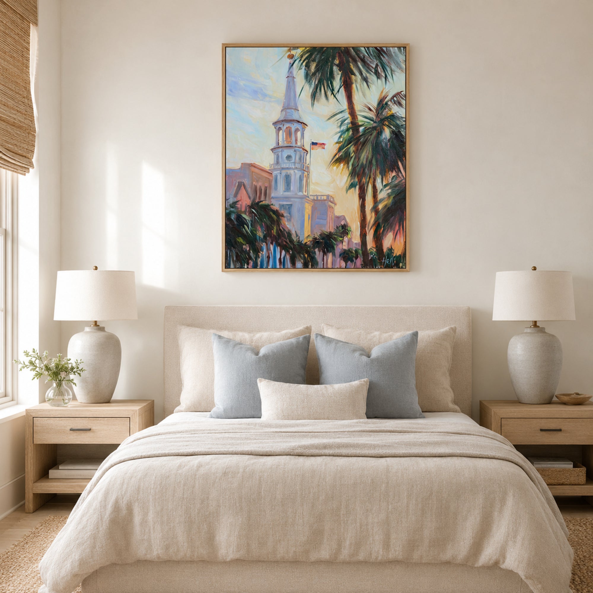 A framed art print depicting a Southern church tower and palm trees, styled in a warm, modern bedroom setting above a neatly made bed with neutral-toned bedding and pillows.
