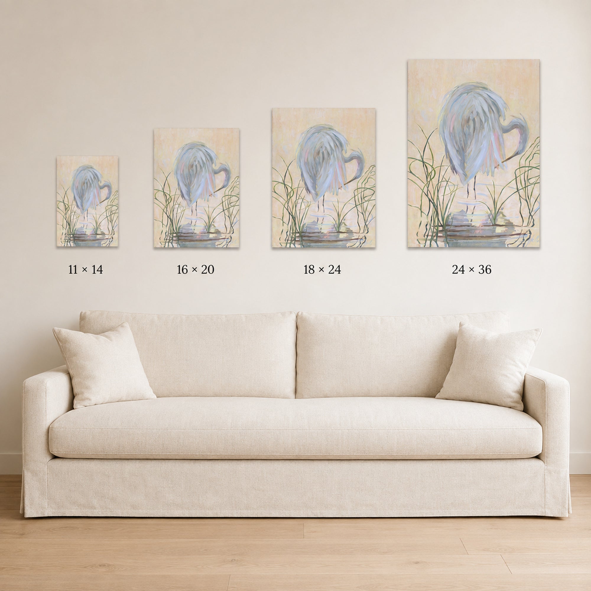 Four vertical canvas prints with blue floral designs are displayed in a row above a cream-colored sofa. The prints are shown in four different sizes with dimension labels underneath: 11 x 14, 16 x 20, 18 x 24, and 24 x 36.