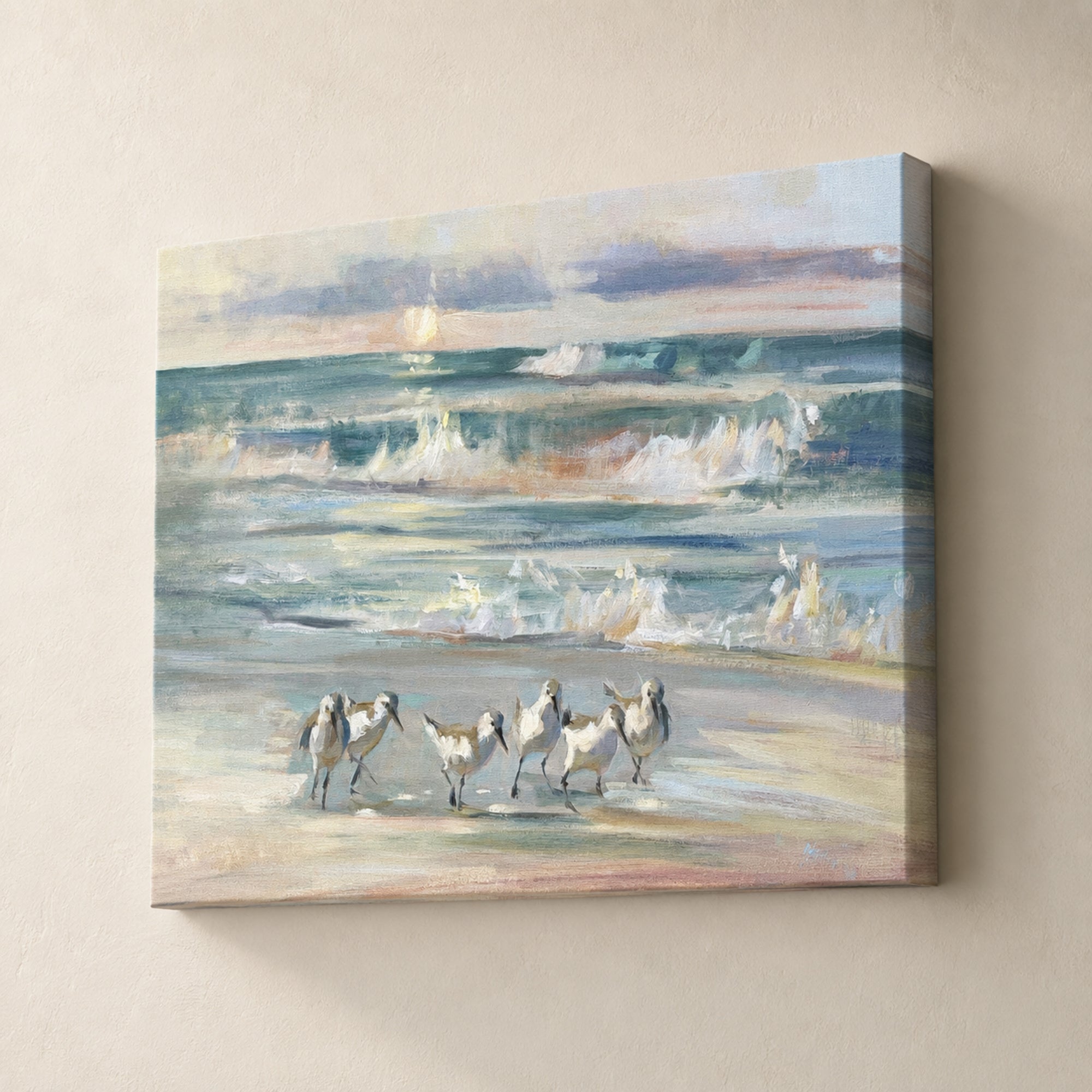 A square canvas wall art print depicting a beach scene with several white birds walking on the shore and waves rolling in behind them, shown hanging on a light beige wall.