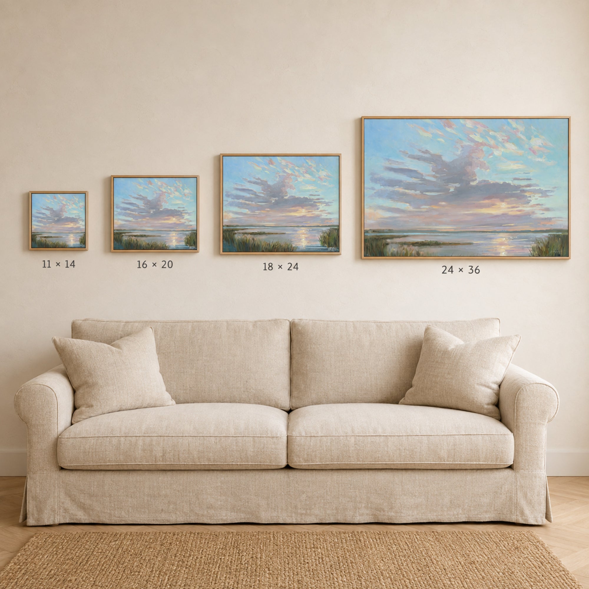 A staged living room scene showing a beige sofa beneath four framed landscape paintings on a cream wall, with size labels under each frame: 11 x 14, 16 x 20, 18 x 24, and 24 x 36.