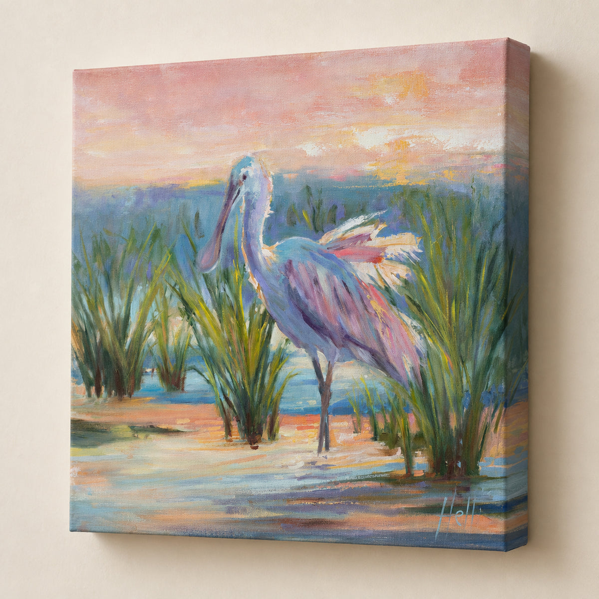 A square canvas wall art print depicting a white and pink spoonbill standing in shallow water among green reeds under a soft pink and orange sky. The canvas is shown at an angle against a light beige wall.