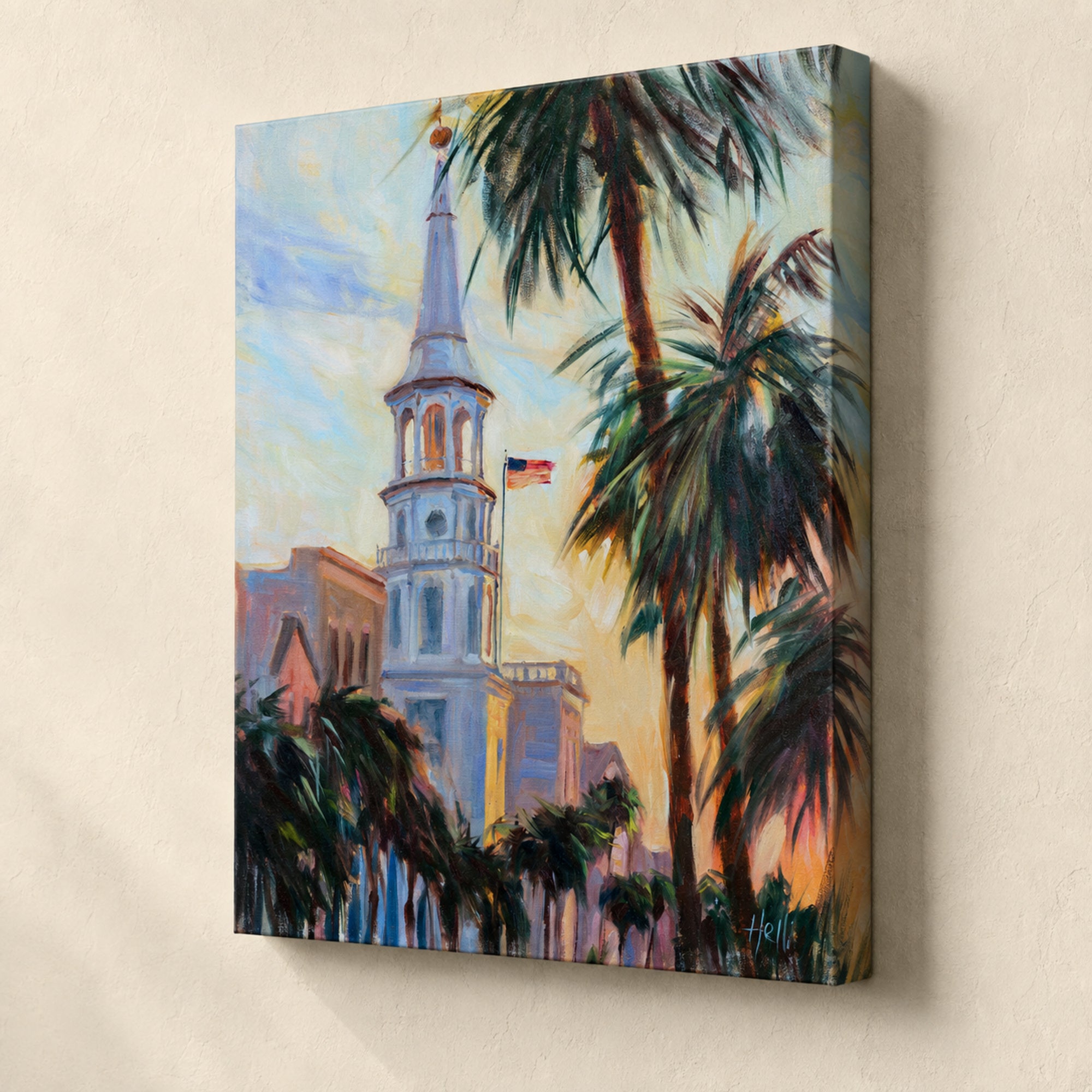 A square canvas wall art print depicting a colorful impressionistic scene of a church steeple and palm trees, shown hanging on a beige wall.
